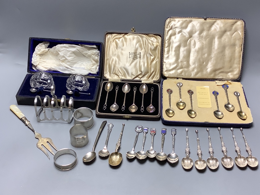 Three cased sets including silver teaspoons, a silver toast rack, three silver napkin rings and a quantity of minor silver flatware.